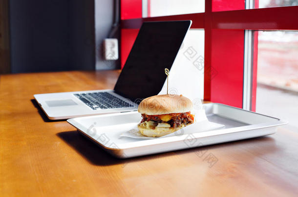 吃在使工作位-快的食物.汉堡包在近处便携式电脑.午餐LV旗下具有女人味与时尚气质的手袋