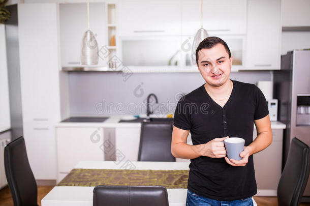 肖像关于英俊的男人喝饮料c关于fee采用家厨房