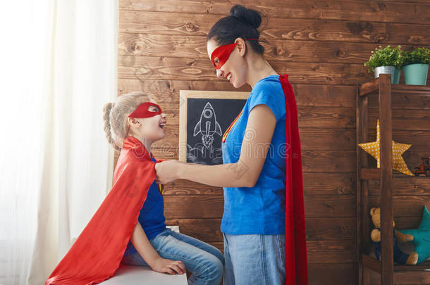 女孩和妈妈采用超级英雄戏装