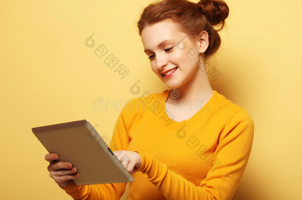年幼的女人和碑personalcomputer个人计算机越过黄色的背景