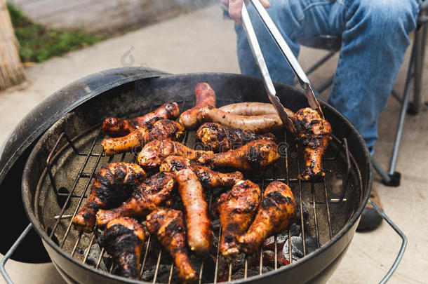 男人烧烤肉向barbecue吃烤烧肉的野餐烧烤