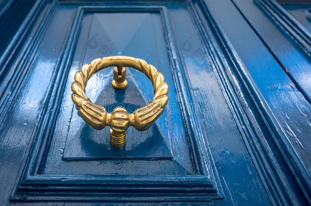 古老的黄铜门门环向蓝色门.