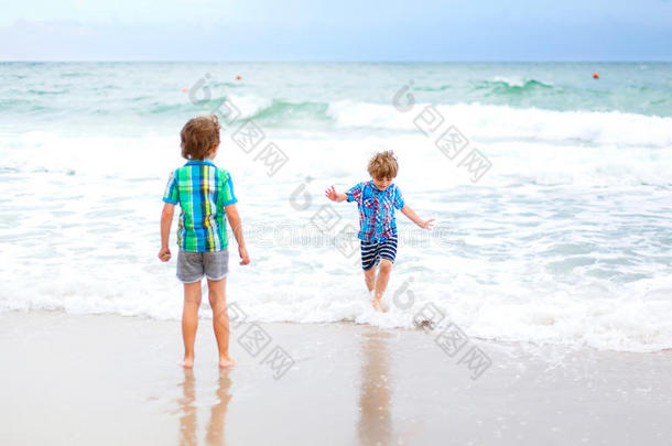 两个<strong>小孩</strong>男孩<strong>跑步</strong>向热带的海滩采用葡萄牙