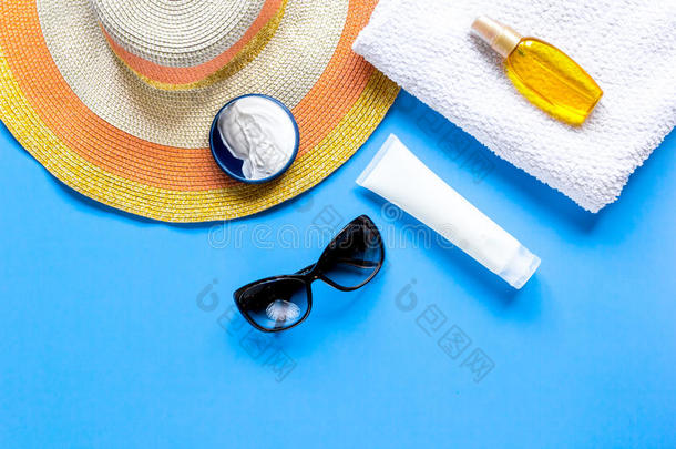 太阳眼镜,注意事项乳霜,帽子,毛巾为海滩休息蓝色波黑