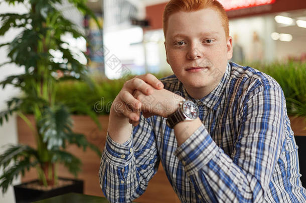 一英俊的红发的人雀斑男孩采用方格图案的衬衫sitt采用g采用舒适的