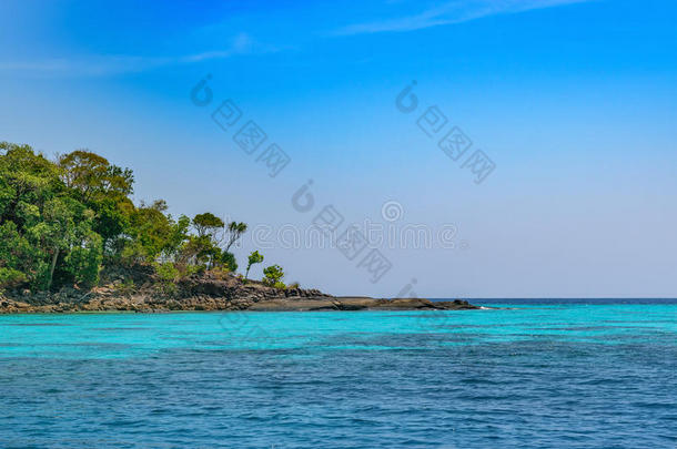 热带的岛海滩和清楚的蓝色环礁湖水和蓝色天