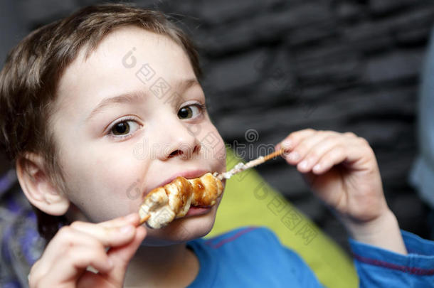 小孩吃鸡烤腌羊肉串