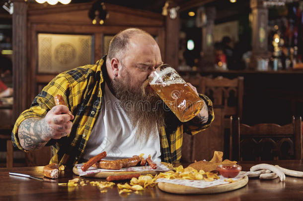幸福的有胡须的男人喝饮料玻璃关于啤酒