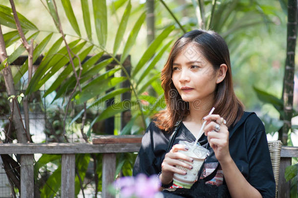 美丽的亚洲人女孩是（be的三单形式吸奶的绿色的茶水采用一咖啡豆商店,h一<strong>pp</strong>