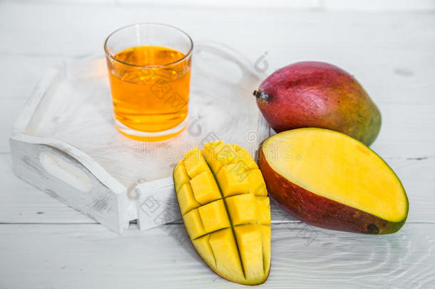 芒果向一白色的木制的b一ckground和果汁