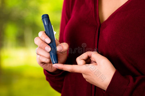女人和红色的毛衣校核血食糖水平在旁边血糖测计仪
