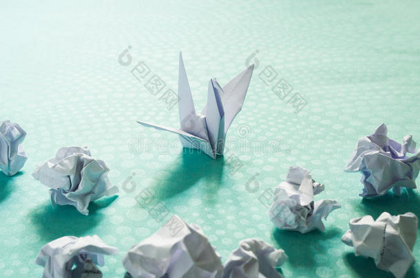 成功观念,一折纸手工纸鸟和摺皱的纸杂乱
