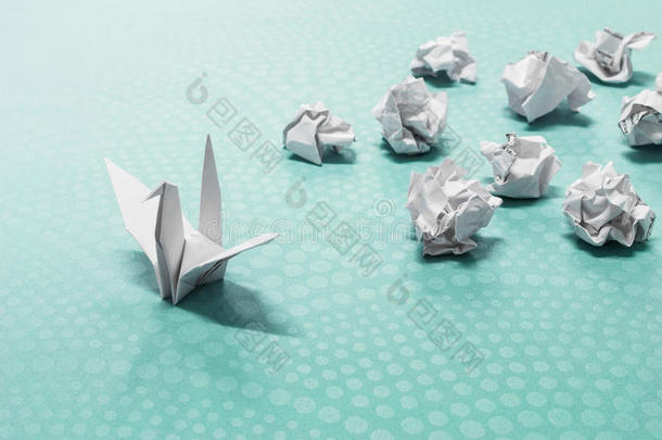 成功观念,一折纸手工纸鸟和摺皱的纸杂乱