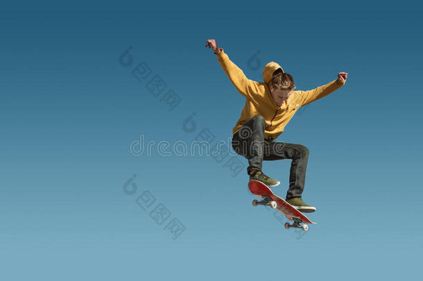 一十几岁的青少年滑板<strong>运动</strong>员做一奥利戏法向背景关于blue蓝色