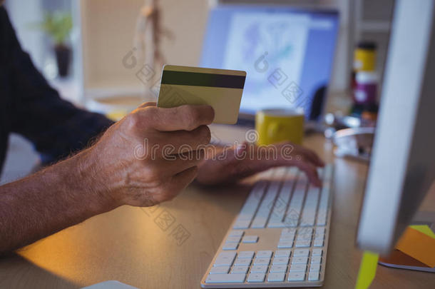 裁切不正的商人购物在线的和信誉卡片在办公室