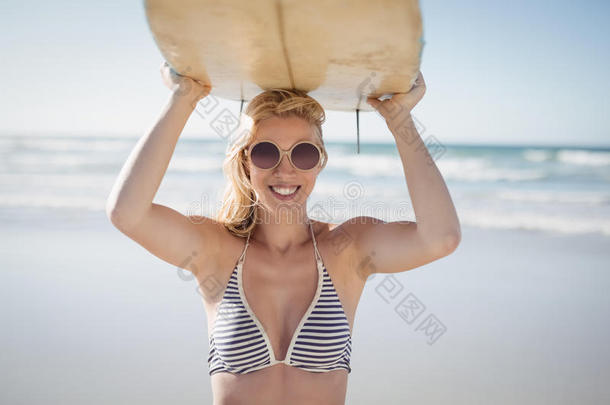 肖像关于幸福的女人运送的冲浪板在海滩