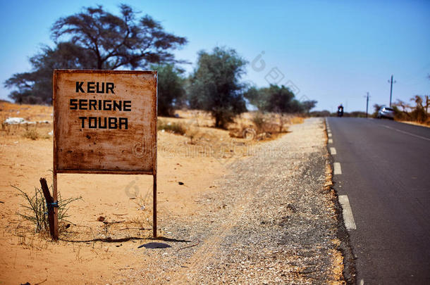 指示牌向向uba采用塞内加尔,背景模糊的沙漠风景