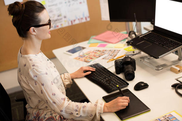 女商人使用计算机在期间工作的向数字<strong>转换器</strong>在办公室
