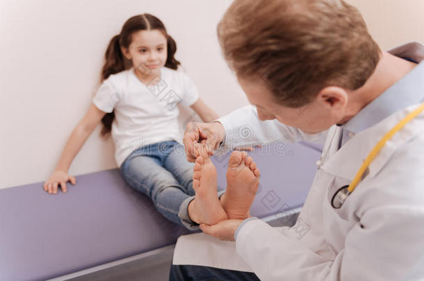 有方法的严谨的医生仔细检查女儿脚趾