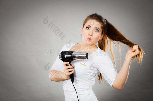 女人烘干她头发使用头发干燥机