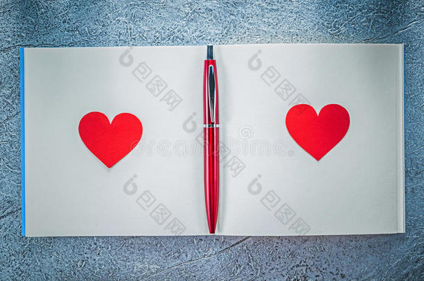 红色的心圆珠笔的一种笔干净的便条簿向金属的背景教育