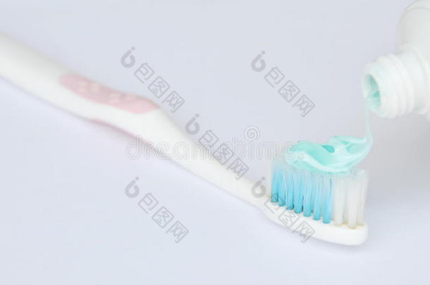 <strong>牙膏挤压</strong>向牙刷采用白色的背景
