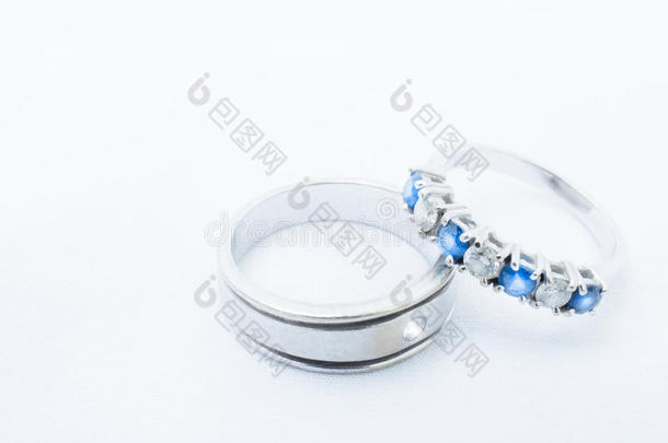 白色的钻石和蓝色经雕琢的宝石向白色的金婚礼戒指机智