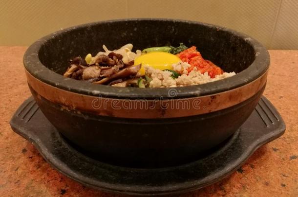 典型的朝鲜食物蔬菜韩式拌饭热的石头罐,稻胡萝卜,