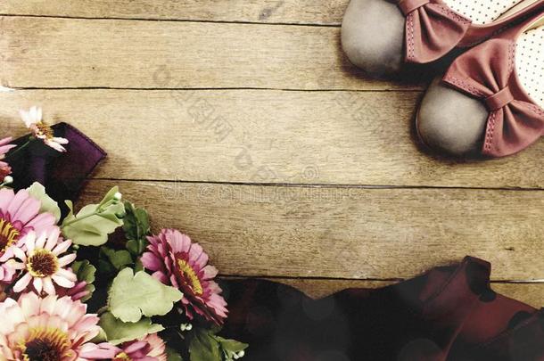 女人平地鞋子和花花束向木制的背景