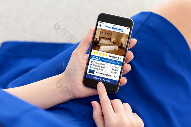 女人采用蓝色衣服hold采用g电话和计算机应用程序旅馆book采用g