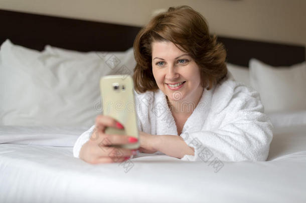 一女人采用浴衣穿着电话采用旅馆房间