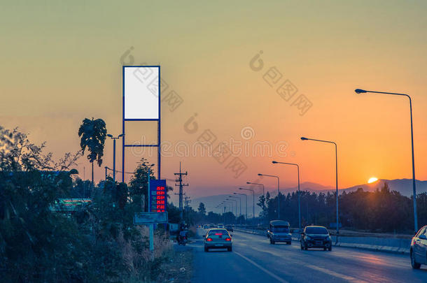 空白的广告牌向汽油st在i向和气体st在i向在日落和