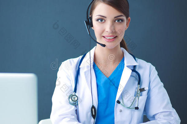 医生使人疲乏的戴在头上的耳机或听筒一次在的后面一书桌和l一ptop