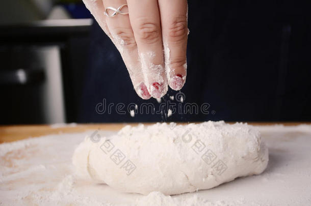 女人手加面粉向生面团.