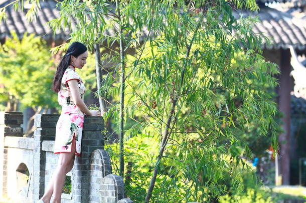 一中国人女人穿着旗袍采用指已提到的人水公园关于劫掠去作水手