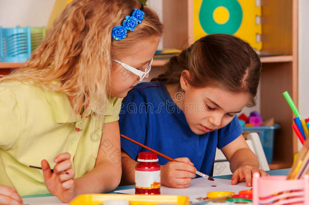 小的学生女孩绘画采用艺术学校班.
