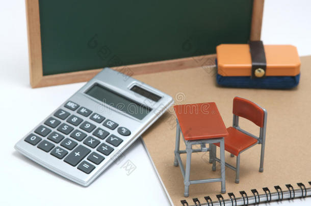 小型的学校书桌,黑板和计算器向白色的后面