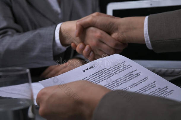 商业人摇动手后的合同签署在会议.