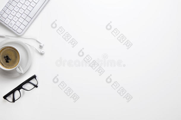 键盘和眼镜,咖啡豆杯子和耳机向白色的书桌