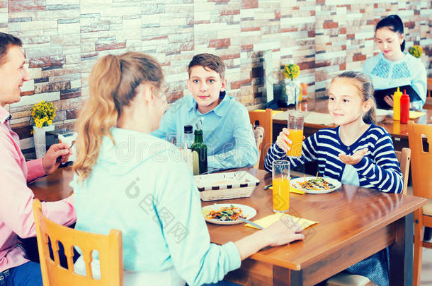 双亲和微笑的孩子们闲谈在的时候正餐采用家庭Cana加拿大