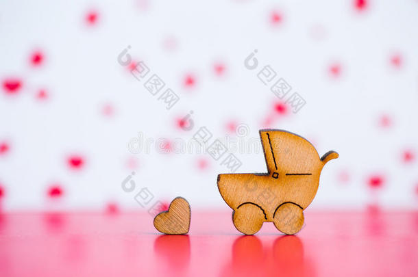 木制的偶像关于婴儿婴儿车和小的心向粉红色的和白色的用绳子拖的平底渡船
