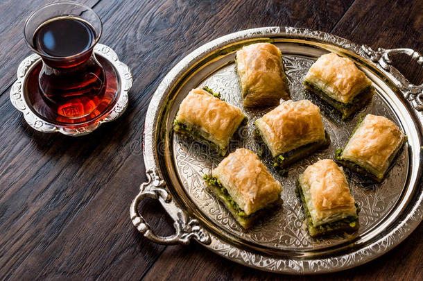 土耳其的餐后甜食蜜糖果仁千层酥和茶水向银盘子.