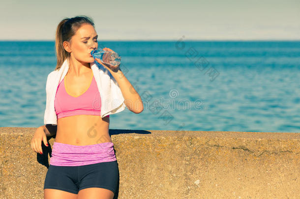 女人喝饮料水后的运动健身房户外的