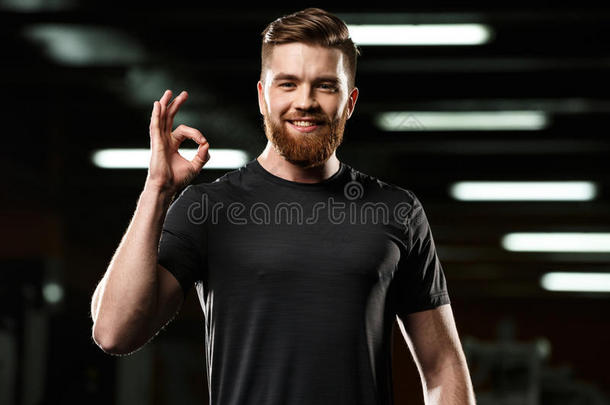 欢乐的有关运动的男人使摆姿势采用健身房show采用g认可手势.