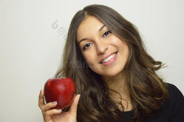肖像关于有魅力的女孩微笑的和红色的苹果采用她手英语字母表的第8个字母