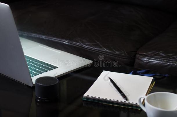 便携式电脑笔记簿和咖啡豆杯子向镜子表和黑的沙发