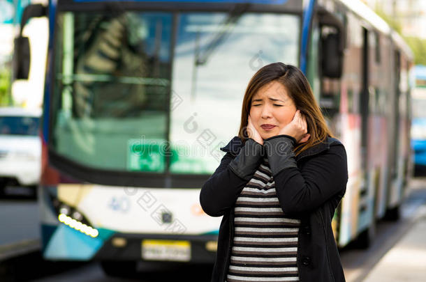 幸福的美丽的年幼的女人掩蔽物她耳和二者手向