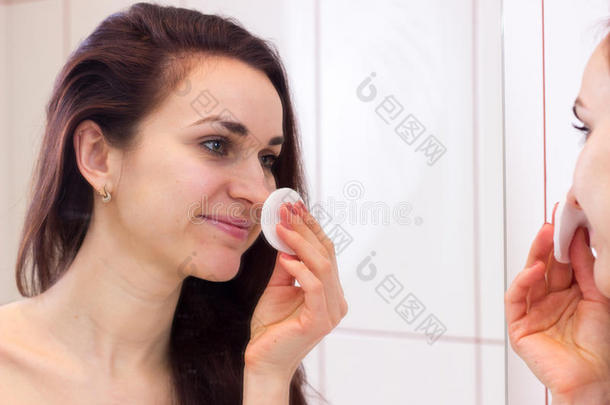 年幼的女人消除化妆采用浴室