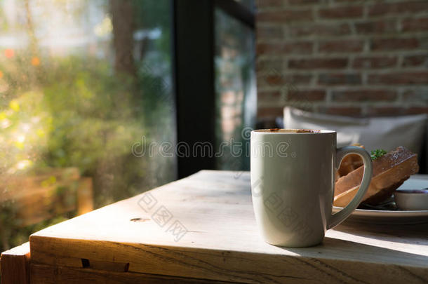 热的摩卡咖啡咖啡豆采用白色的杯子和变模糊华夫饼向指已提到的人木制的英语字母表的第20个字母