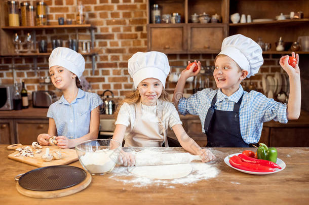 孩子们制造意大利薄饼生面团和准备的意大利薄饼组成部分